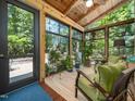 Cozy sunroom featuring wood ceiling, large windows and seating with plants at 4210 Falls River Ave, Raleigh, NC 27614