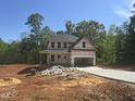 New home construction showing the exterior framework and concrete driveway on a sunny day at 5516 Jaeger Dr # 75, Graham, NC 27253
