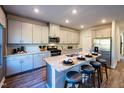 Modern kitchen boasts a large island with seating and stainless steel appliances at 613 White Birch Ln, Angier, NC 27501