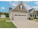 Attached two car garage with a spacious driveway and shed, featuring durable construction at 63 Whistling Duck Way, Wendell, NC 27591