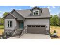 Inviting new construction home showcasing stone accents, a two-car garage, and a charming teal front door at 65 Leisure Ln # 6, Louisburg, NC 27549