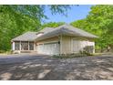 Spacious three-car garage with a screened-in porch, complemented by manicured landscaping and a paved driveway at 6600 Maynard Farm Rd, Chapel Hill, NC 27516