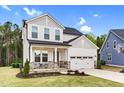 Lovely two-story home with a gray roof, two-car garage, and a quaint front porch area at 67 Comfort Ct, Fuquay Varina, NC 27526