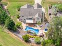 Stunning aerial view of the backyard featuring a swimming pool, patio, and lush landscaping at 6925 Rex Rd, Holly Springs, NC 27540