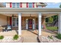 Inviting front porch with ceiling fans, stone accents, and a well-manicured lawn at 6925 Rex Rd, Holly Springs, NC 27540