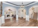 Open-concept living area with hardwood floors, elegant archways, and neutral paint at 6925 Rex Rd, Holly Springs, NC 27540