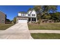 Charming two-story home featuring a stone facade, white accents, and a well-manicured lawn at 705 Blue Pointe Path, Apex, NC 27523