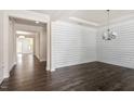 Bright dining room with modern chandelier, shiplap accent wall and dark hardwood floors at 7104 Rex Rd, Holly Springs, NC 27540