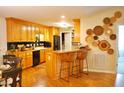 Bright kitchen with wood cabinets, a breakfast bar, and seamless flow into the living area at 738 Aspenwood Dr, Graham, NC 27253