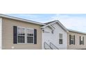 Inviting exterior featuring beige siding, black shutters, and a covered entryway at 765 Whitley Rd, Middlesex, NC 27557
