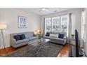 Bright living room with neutral walls, large windows, and comfortable seating arrangement at 7838 Spungold St, Raleigh, NC 27617