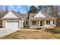 Charming single-story home featuring a two-car garage and a welcoming front porch during the day at 95 Leisure Ln # 9, Louisburg, NC 27549
