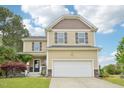 Inviting two-story home with a well-maintained lawn and two-car garage, providing comfortable suburban living at 100 Winterberry Ln, Holly Springs, NC 27540