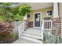 Charming front porch with decorative stone accents, white railings, and a welcoming entrance at 100 Winterberry Ln, Holly Springs, NC 27540