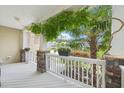 Cozy front porch with white railings, stone columns, and lush greenery, offering a relaxing outdoor space at 100 Winterberry Ln, Holly Springs, NC 27540