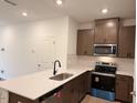 A well-equipped kitchen featuring stainless steel appliances, cabinetry and quartz countertops at 1031 Mountain Crown St, Durham, NC 27703