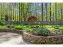 Backyard garden with stone retaining wall and colorful flowers and lush landscaping at 10609 Lowery Dr, Raleigh, NC 27615