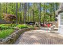Backyard brick patio and stone retaining wall, complete with outdoor seating and a grill area at 10609 Lowery Dr, Raleigh, NC 27615