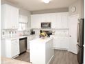 Bright kitchen featuring white cabinetry, stainless steel appliances, and marble countertops at 10943 Pendragon Pl, Raleigh, NC 27614