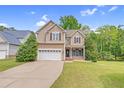 Traditional two-story home featuring a spacious driveway, lush lawn, and well-maintained landscaping at 11 Glen Valley Ct, Angier, NC 27501