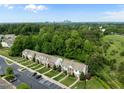 Aerial view of suburban townhomes surrounded by lush trees and near the city skyline at 1109 Renewal Pl, Raleigh, NC 27603