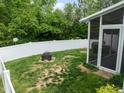 Fenced backyard with a fire pit and leads to a screened-in porch at 1109 Renewal Pl, Raleigh, NC 27603