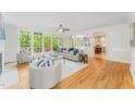 Bright living room boasts hardwood floors, large windows and an open layout into the kitchen at 111 Murdock Creek Ct, Cary, NC 27519