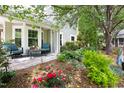 Charming backyard patio featuring a seating area surrounded by lush landscaping and colorful flowers at 111 Sir Richard Ln, Chapel Hill, NC 27517