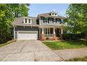 Charming two-story home featuring a brick-accented porch and attached two-car garage at 11808 Venture Oak Way, Raleigh, NC 27613