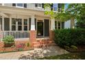 Close-up of the home's inviting front porch with brick accents and charming details at 11808 Venture Oak Way, Raleigh, NC 27613