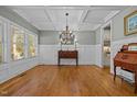 Elegant dining room with coffered ceilings, hardwood floors, and a stylish chandelier at 1209 Kingston Ridge Rd, Cary, NC 27511