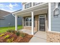 Inviting front porch with brick accents and decorative columns welcomes you home at 1302 Cricket St, Elon, NC 27244