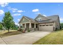 A well-maintained home with a two-car garage, appealing front porch, and a lush lawn at 1305 Chronicle Dr, Durham, NC 27703