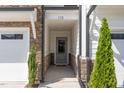 Inviting covered entryway with stone accents, leading to a modern front door of townhome at 132 Deardom Way, Chapel Hill, NC 27516