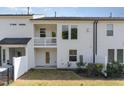 Rear exterior view of the home showing the balcony, white siding and small backyard at 132 Deardom Way, Chapel Hill, NC 27516