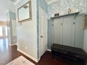 Welcoming entryway featuring hardwood floors, a mirror, a coat rack, and stylish blue wallpaper at 1320 Double Oak Ln, Willow Springs, NC 27592