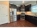 Well-equipped kitchen with stainless steel appliances, dark cabinetry, and hardwood floors at 1320 Double Oak Ln, Willow Springs, NC 27592