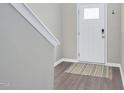 Inviting foyer with a white front door, wood-look floors, neutral wall paint and white trim at 136 River Pearl St, Raleigh, NC 27603