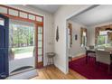 Inviting entryway with wood floors leading to a dining room and views of the lush outdoors at 1415 Meadow Wind Ln, Hillsborough, NC 27278