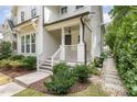 Inviting front porch with a modern railing, lush landscaping, and a concrete walkway at 1422 Banbury Rd, Raleigh, NC 27607