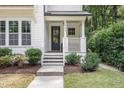 Welcoming entrance featuring a covered porch, stylish door, and manicured shrubbery at 1422 Banbury Rd, Raleigh, NC 27607