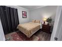 Cozy bedroom with plush bedding, neutral color palette, area rug, bedside table and a lamp at 1436 Sedwick Rd, Durham, NC 27713