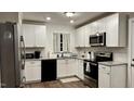 Bright kitchen featuring white cabinets, stainless steel appliances, granite countertops, and modern fixtures at 1436 Sedwick Rd, Durham, NC 27713