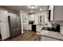 Well-lit kitchen features white cabinets, stainless steel appliances, granite countertops, and a laundry room at 1436 Sedwick Rd, Durham, NC 27713