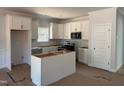 Bright, unfinished kitchen with white cabinets, modern appliances, and ample countertop space awaiting customization at 200 Green Pines Estates Dr, Kenly, NC 27542