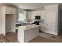Bright kitchen featuring white cabinets, a stylish island, stainless steel appliances, and a window providing natural light at 200 Green Pines Estates Dr, Kenly, NC 27542