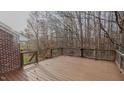 Spacious wooden deck with a metal and wood railing, overlooking the trees at 208B Mallard Creek Dr, Graham, NC 27253
