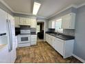 Kitchen featuring white cabinets, tile backsplash, and modern appliances at 208B Mallard Creek Dr, Graham, NC 27253