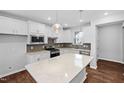 Spacious kitchen with white cabinets, stainless appliances, granite countertops, and center island at 2328 Beeblossom Pl, Fuquay Varina, NC 27526