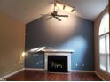Bright living room with a fireplace, vaulted ceilings, and modern ceiling fan at 2416 Fields Of Broadlands Dr, Raleigh, NC 27604